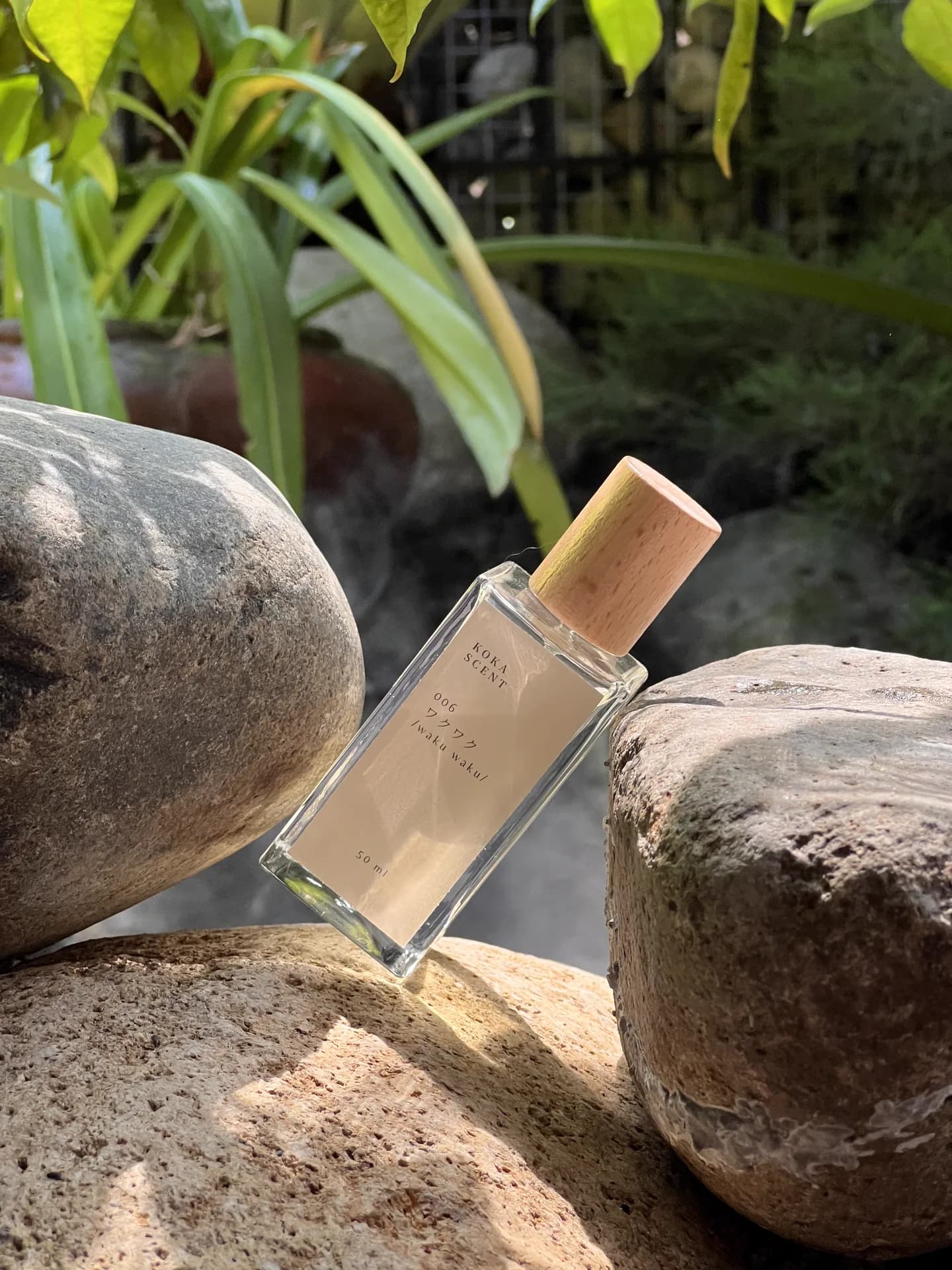 Deretan botol parfum kaca dengan tutup kristal di bawah cahaya hangat